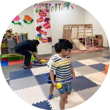 Children playing with hoops and balls in a Della Junior classroom